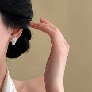 Detailed macro view of exquisite zircon-encrusted flower basket earrings on ear
