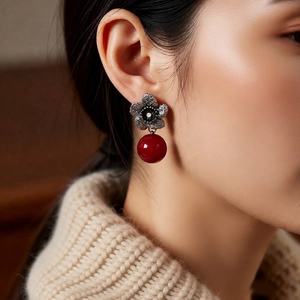 Detailed close-up of vintage flower earrings with red beads and silver-tone petals