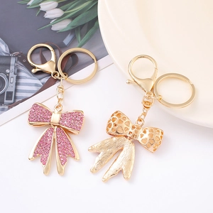 Portachiavi con fiocco di strass rosa e ciondolo a cuore dorato per borse da donna