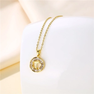 Detail of 18K gold letter T pendant with baguette cubic zirconia stones on O-chain