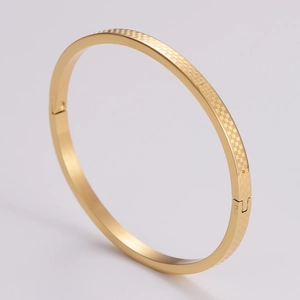 Detailed side view of golden checkered pattern bangle with a secure hinge clasp