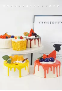 Detailed view of 10cm realistic jam mousse cake models with faux fruit toppings