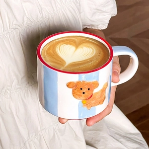Detail of hand-painted ceramic mug with blue stripes, embossed puppy, and heart latte art