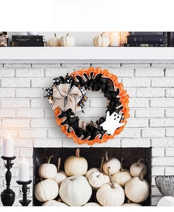 Halloween ghost wreath with burlap bows and orange fabric displayed on a white fireplace