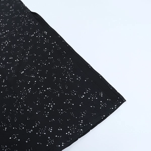 Gros plan sur le tissu noir avec des paillettes argentées scintillantes et des détails
