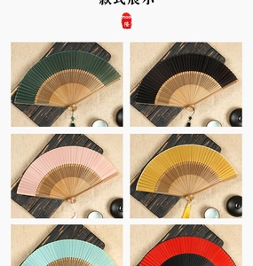 Detail of silk folding fans in various colors with bamboo ribs and matching tassels