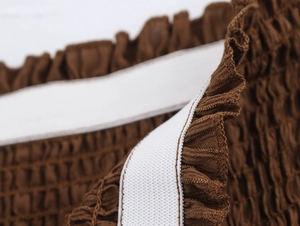 Detail shot of brown smocked fabric with white elastic band stitching for beach set