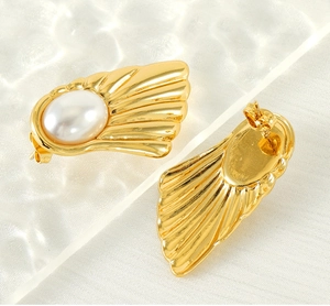Detailed view of 18K gold-plated fan-shaped earrings with central pearl on textured background