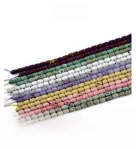 Macro detail of colorful 6x8mm geode agate barrel beads with natural textured surfaces
