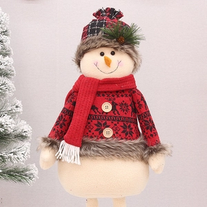 Detail of plush Christmas snowman doll featuring red knit sweater and pine cone accent