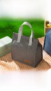 Detail of grey insulated lunch bag showing its knit texture and Tasty Food leather label