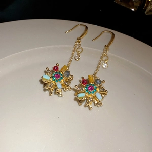 Gros plan de boucles d'oreilles vintage dorées avec résine et pierres colorées