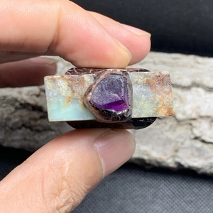 Detailed macro view of raw purple amethyst and green gemstone on vintage bronze ring