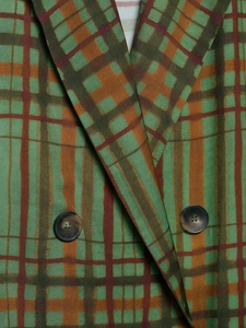 Detailaufnahme des grün-braunen Karo-Blazers mit zweireihigen Knöpfen und Revers