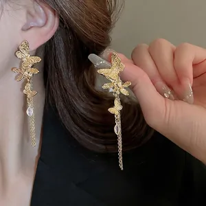 Elegant gold butterfly tassel earrings with cubic zirconia crystals shown on model
