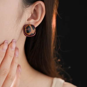 Gros plan de boucles d'oreilles léopard avec bordure rouge sur le mannequin