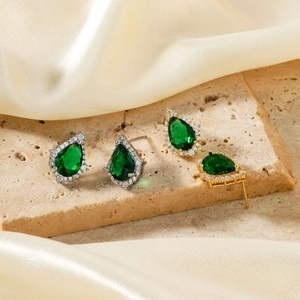 Elegant pear cut emerald green stud earrings with halo diamonds in gold and silver