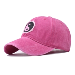 Dettaglio cappello in cotone lavato rosa con toppa ricamata cuore yin yang