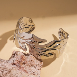 Detail of silver leaf cuff bracelet showing polished veins on a natural stone base
