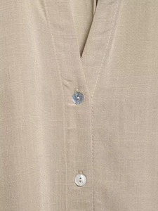 Detail of khaki linen shirt featuring a V-neckline and iridescent shell buttons