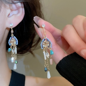 Détail macro de boucles d'oreilles bohèmes avec disques bleus et perles de cristal