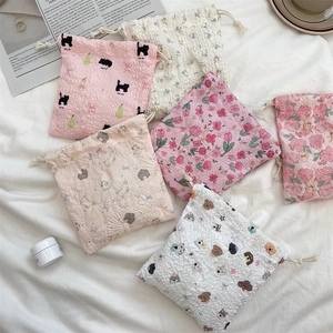 Close-up of assorted drawstring storage bags in seersucker fabric with cute cartoon patterns