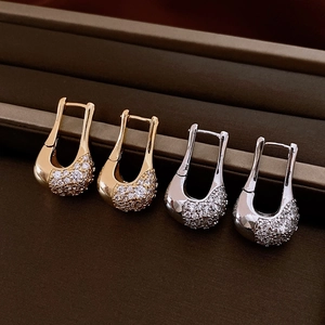 Detailed close-up of U-shaped hoop earrings with gold and silver pavé-set cubic zirconia