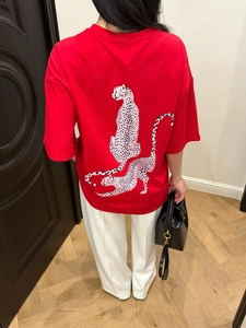 Detail of red oversized T-shirt featuring pink leopard print on back with drop shoulder cut