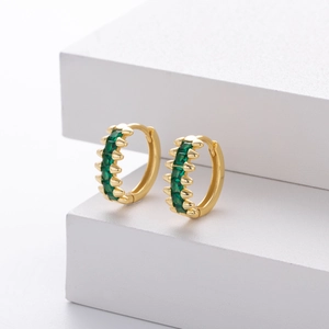 Detail view of gold hoop earrings featuring vibrant square-cut emerald green zircons