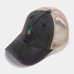 Detail of pineapple embroidery on vintage mesh baseball cap with washed cotton texture