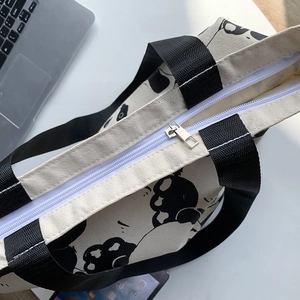 Detail of panda canvas tote bag featuring secure zipper closure and internal pocket