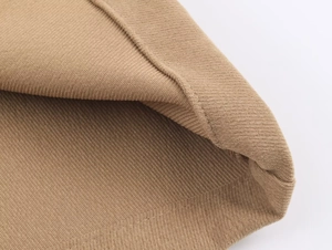 Gros plan sur le tissu en maille côtelée kaki montrant la texture et les coutures