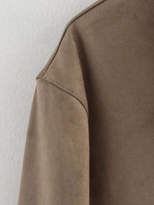 Close-up of brown faux suede jacket shoulder showing precision stitching and fabric texture