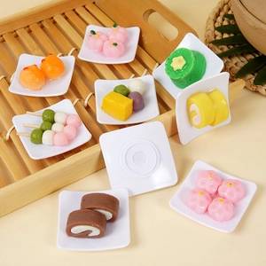 Portachiavi con cibo in miniatura e dolci assortiti su piatti bianchi in vassoio di bambù