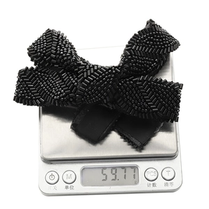 Handmade black beaded bow hair clip showing elegant texture and 59.77g weight scale