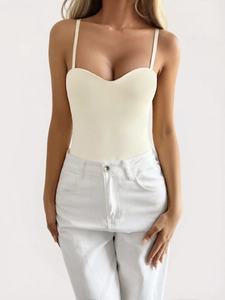 Detail view of cream bodysuit with slim straps and sweetheart neckline on model