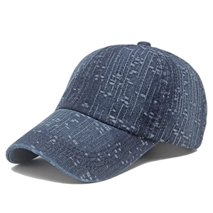 Detailed view of the dark blue washed denim fabric and textured jacquard on the baseball cap