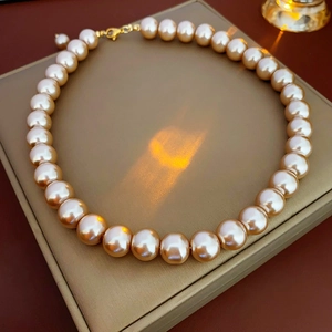 Close-up of elegant champagne pearl necklace with gold clasp on a luxury display box