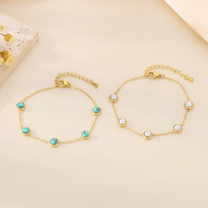 Bracelets dorés avec perles de turquoise et perles blanches sur papier texturé