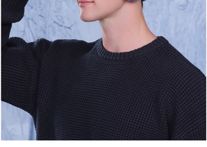 Detailed view of men's navy knit beanie with ear flaps and warm waffle texture