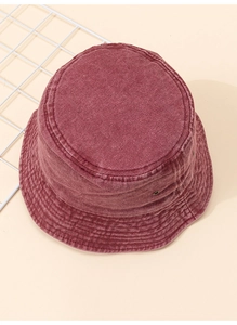 Détail de la texture en denim délavé d'un bob rouge foncé vintage pour protection solaire