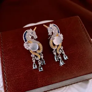 Elegant unicorn drop earrings in silver and gold with sparkling blue gemstones