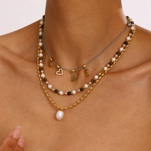 Dettaglio della collana a strati in acciaio inossidabile con perle e ciondolo a cuore