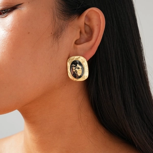 Vue détaillée de boucles d'oreilles ovales rétro avec motif carrosse sur le mannequin