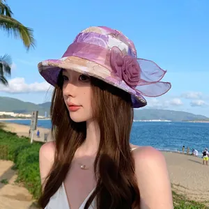 Women's summer sun hat with purple floral accent and breathable textured fabric