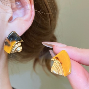 Macro detail of geometric resin earring with 18k gold plating and tortoiseshell pattern