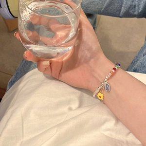 Detalle de pulsera de cuentas plateadas con cuentas de cubos de colores y colgante de suerte Fu