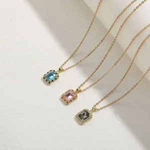 Detailed shot of gold necklaces featuring blue, pink, and grey rectangular gemstones