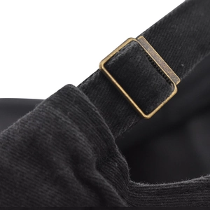 Detail of adjustable metal buckle and vintage denim fabric on the black baseball cap