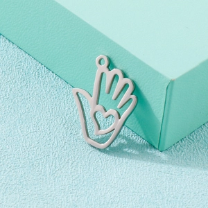 Minimalistischer Edelstahl-Palm-Anhänger mit hohlem Herz-Ausschnitt auf grünem Hintergrund